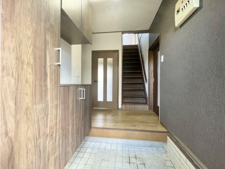 ダークグレーと木目のコントラストが印象的な玄関。玄関を上がると、右にダイニングキッチン、左に洗面や浴室などの水回り、正面に階段があり、どのスペースにも移動しやすい間取りになっています。