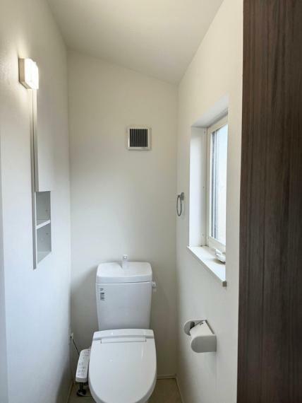 【トイレ】清潔感があり、温水洗浄便座付きのトイレ。便利な収納棚も設置した、使いやすさを重視する造りになっております