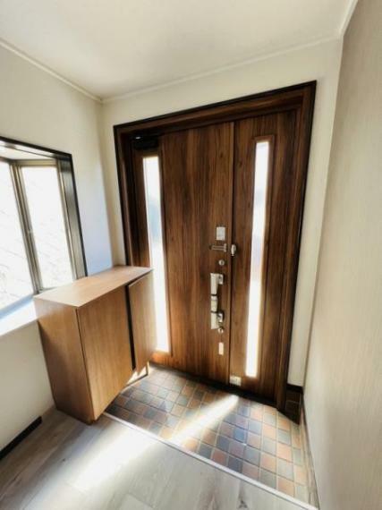出窓とスリット窓の2方向からの光で明るい印象の玄関スペース。