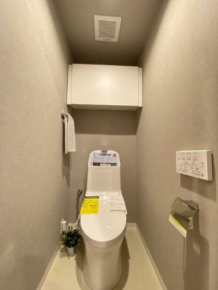 清潔感溢れる温水洗浄便座付きのトイレも完備。トイレ用品がスッキリ片付く上部吊戸棚も備え付け。