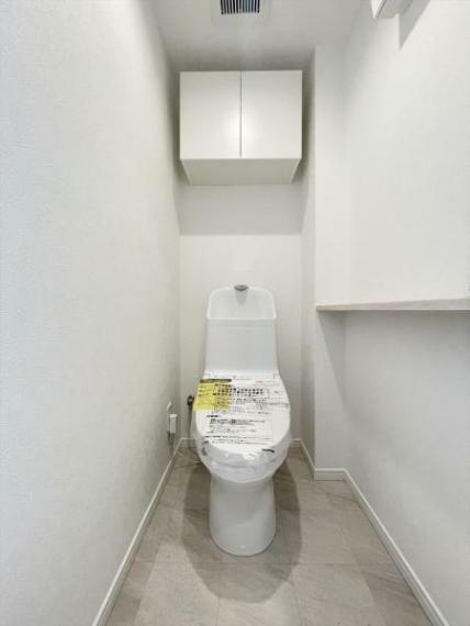 白を基調にした清潔感のあるトイレには、便利な吊戸棚を設置