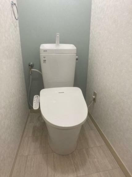 温水洗浄便座搭載のトイレです。 淡いブルークロスや清潔感のある配色が空間を彩ります。 温水洗浄機能により衛生的なトイレタイムを提供。長時間の使用でも快適さを維持します。