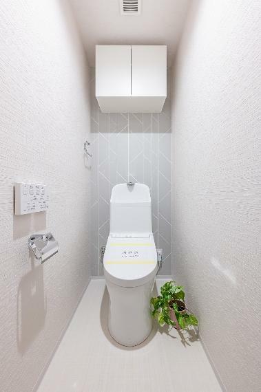 年中快適に使える温水洗浄機能付きのトイレ。トイレ背面に吊戸棚を設置