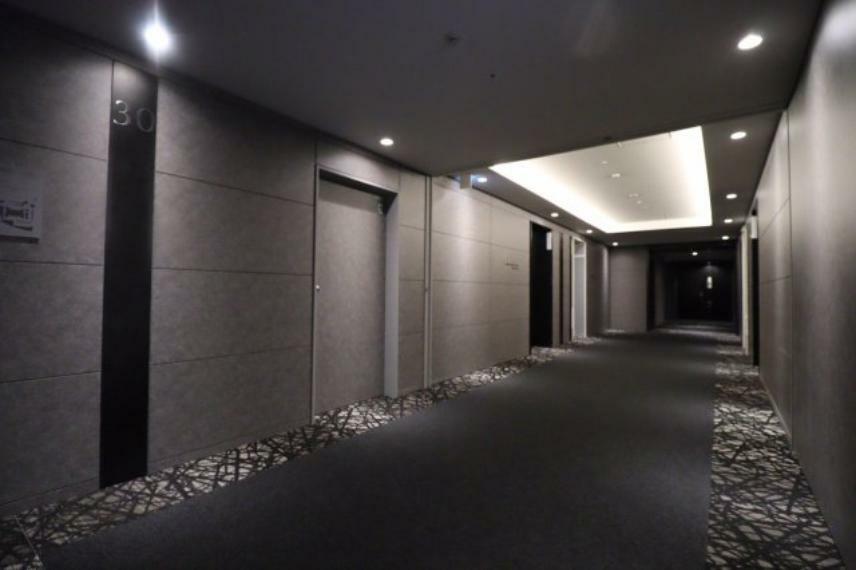 【内廊下】ダウンライトが照らし出す、カーペット敷きのシックな廊下。黒を基調とした統一感あるテイスト