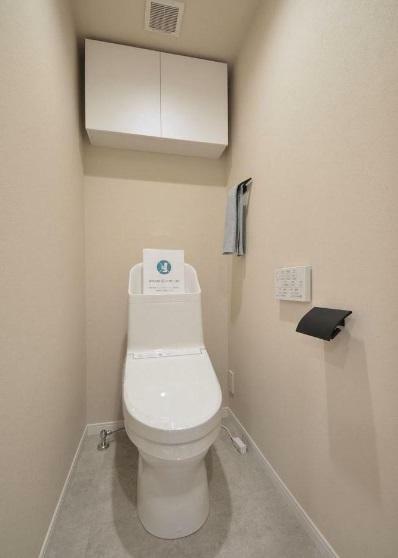 お掃除の手間を減らしてくれる温水洗浄トイレ。上部に吊戸棚設置。