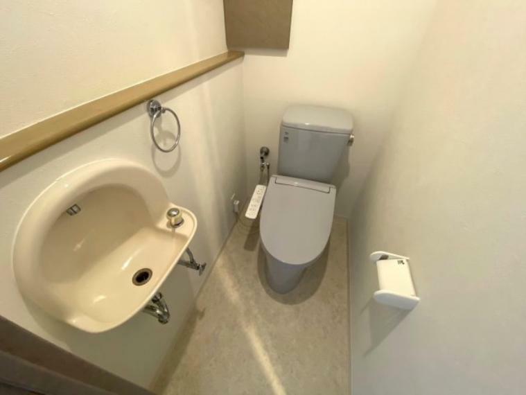 シンプルで機能的なミニ手洗い場付カウンターのあるトイレ。ウォシュレット付。