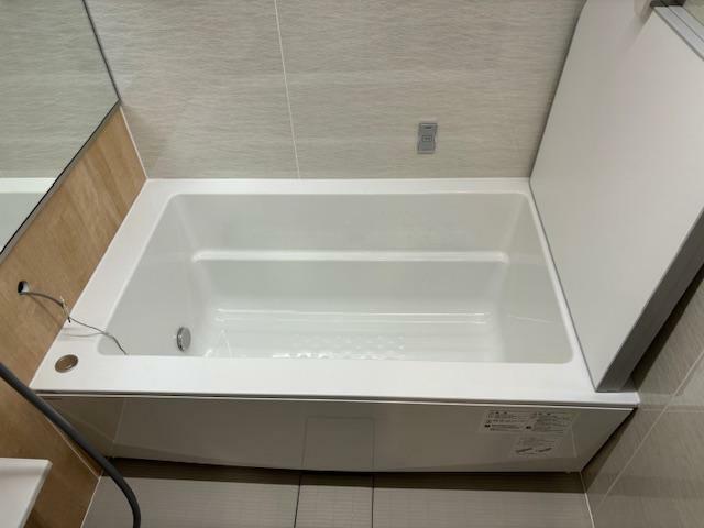 保温浴槽のバスタブ。壁に見えるスイッチはバスルーム内の照明を暖色に変えることができ、リラックスタイムを演出します。