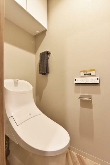 温水洗浄機能付きのトイレには上部吊戸棚があり、掃除用具なども収納可能です。