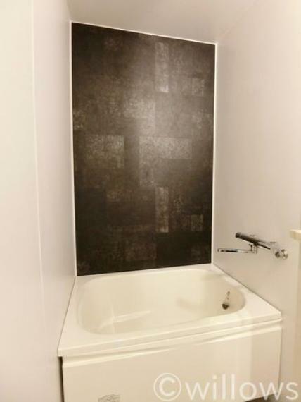 浴槽横の壁面をアクセントクロスに。一日の疲れを癒す空間は、白が基調のお部屋の中でどこかシックな雰囲気を味わうことができます。