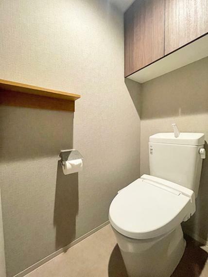 シンプルで落ち着くデザインのトイレ。トイレットペーパーなどをストックできる便利な吊戸棚もあります。