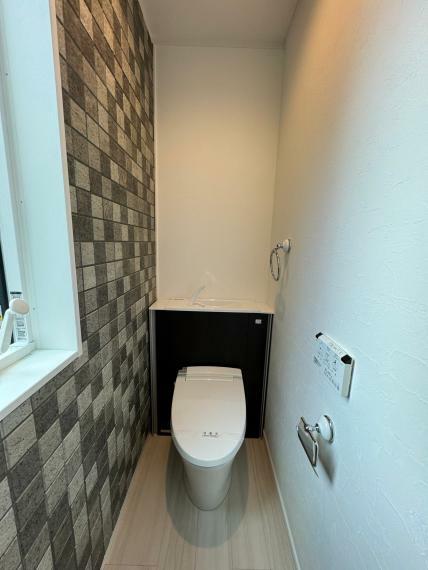 壁のタイルがお洒落な1階トイレ。